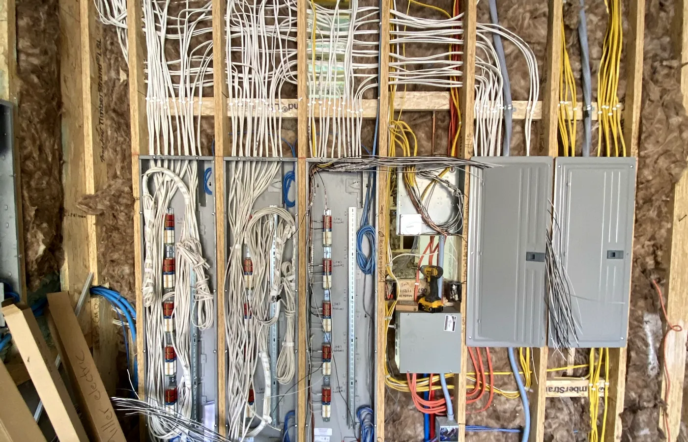 The head-end wall at first fix — lighting panels, structured cabling and power