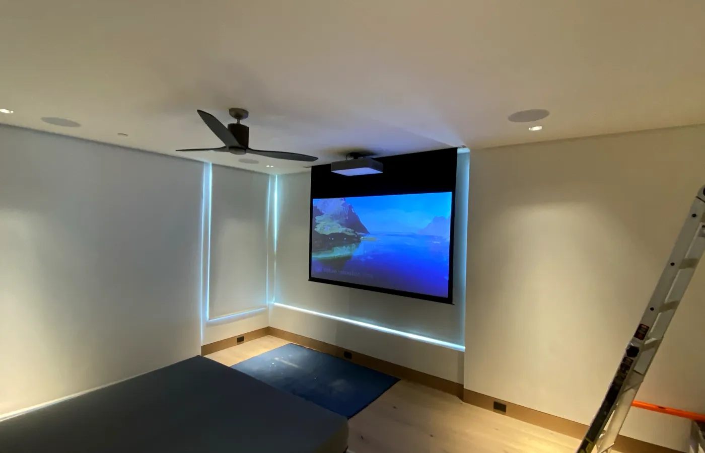 The same room with the screen down, speakers flush in the ceiling